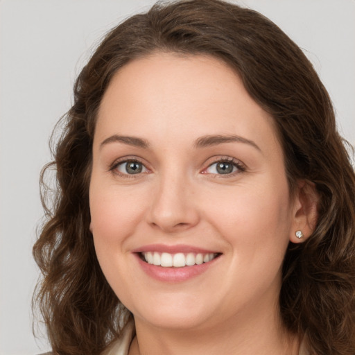 Joyful white young-adult female with medium  brown hair and green eyes