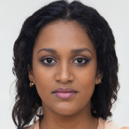 Joyful black young-adult female with long  brown hair and brown eyes