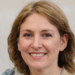 Joyful white adult female with medium  brown hair and blue eyes