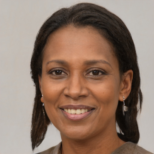 Joyful black adult female with medium  brown hair and brown eyes