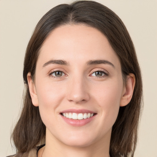 Joyful white young-adult female with long  brown hair and grey eyes