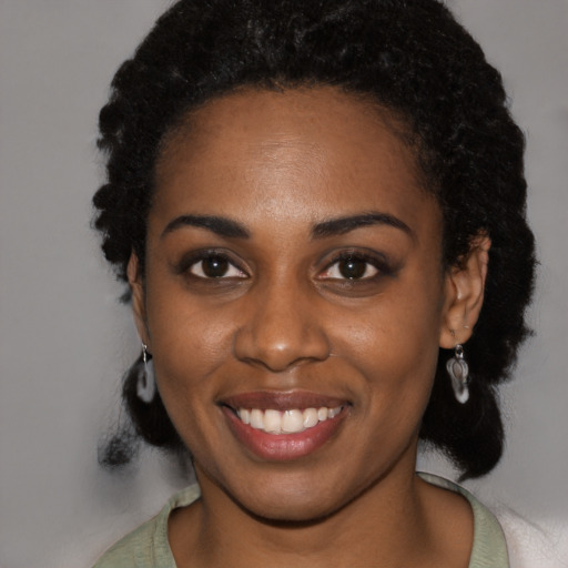 Joyful black young-adult female with short  black hair and brown eyes