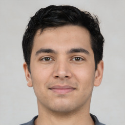 Joyful latino young-adult male with short  brown hair and brown eyes