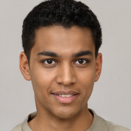 Joyful black young-adult male with short  brown hair and brown eyes