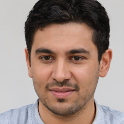 Joyful white young-adult male with short  black hair and brown eyes