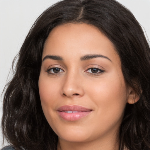 Joyful latino young-adult female with long  brown hair and brown eyes