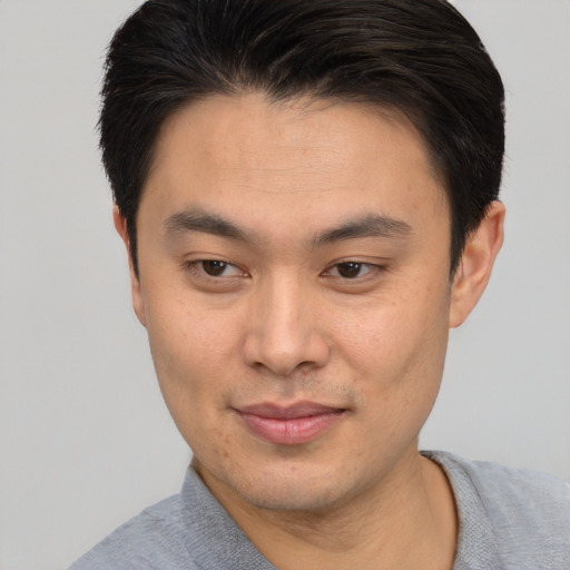 Joyful asian young-adult male with short  brown hair and brown eyes