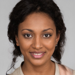 Joyful black young-adult female with long  brown hair and brown eyes