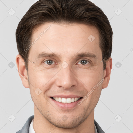 Joyful white young-adult male with short  brown hair and grey eyes