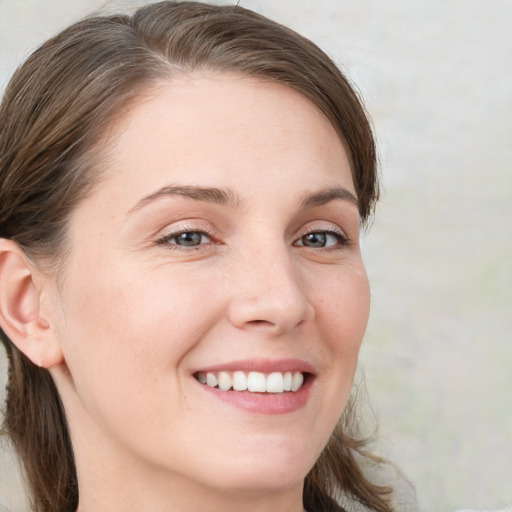 Joyful white young-adult female with medium  brown hair and blue eyes