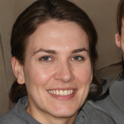 Joyful white adult female with medium  brown hair and brown eyes