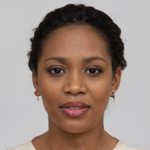 Joyful black young-adult female with short  black hair and brown eyes