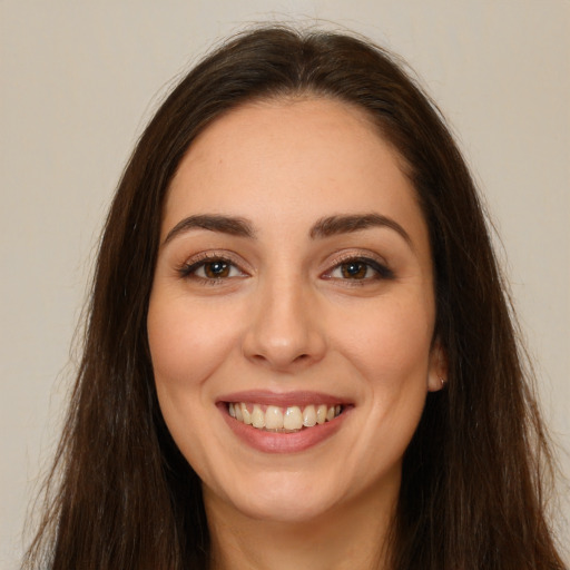 Joyful white young-adult female with long  brown hair and brown eyes