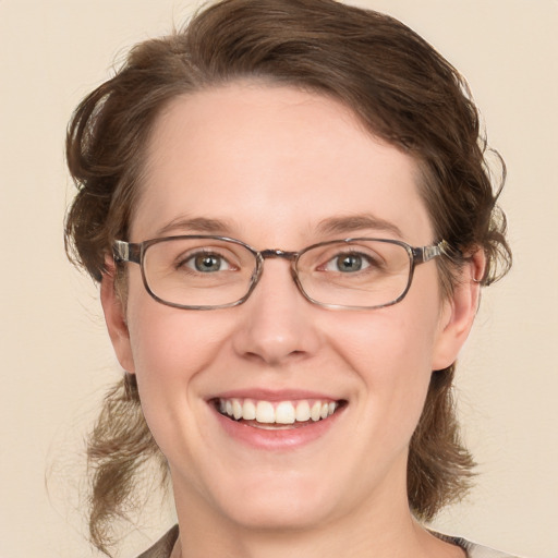 Joyful white adult female with medium  brown hair and blue eyes