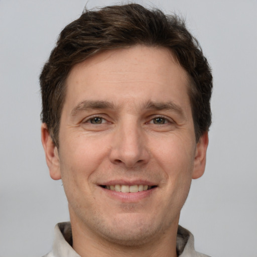 Joyful white adult male with short  brown hair and grey eyes