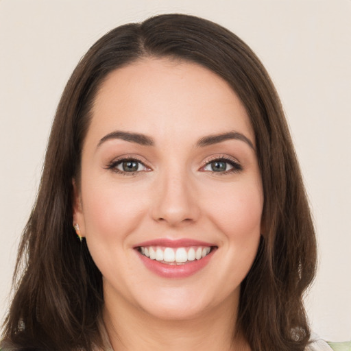 Joyful white young-adult female with long  brown hair and brown eyes