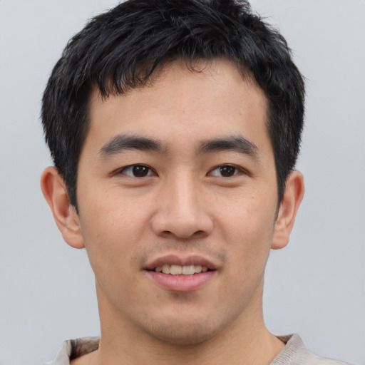 Joyful asian young-adult male with short  brown hair and brown eyes