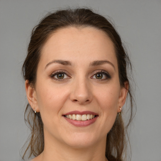 Joyful white young-adult female with medium  brown hair and grey eyes