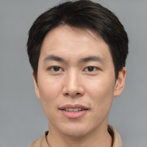Joyful asian young-adult male with short  brown hair and brown eyes