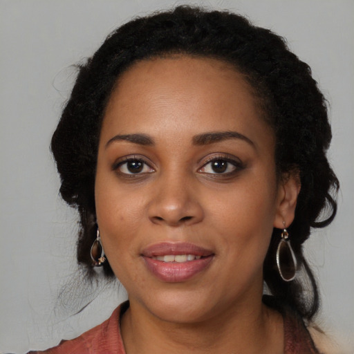 Joyful black young-adult female with long  black hair and brown eyes