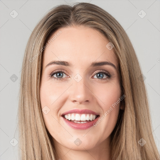 Joyful white young-adult female with long  brown hair and brown eyes