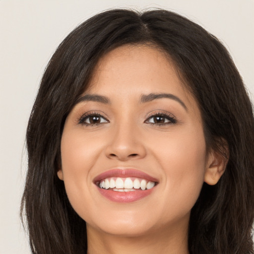 Joyful white young-adult female with long  brown hair and brown eyes