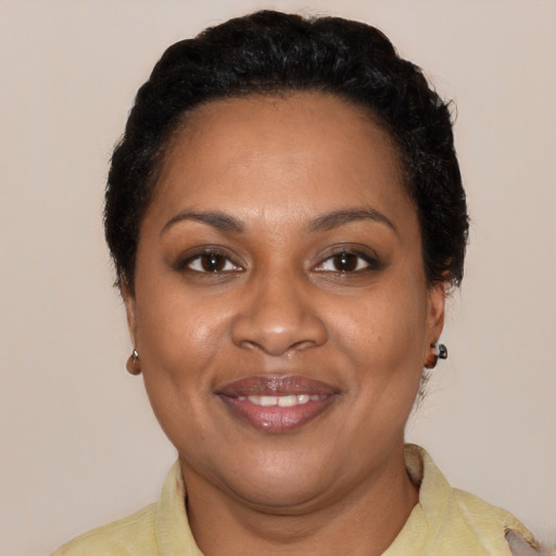 Joyful black young-adult female with short  black hair and brown eyes