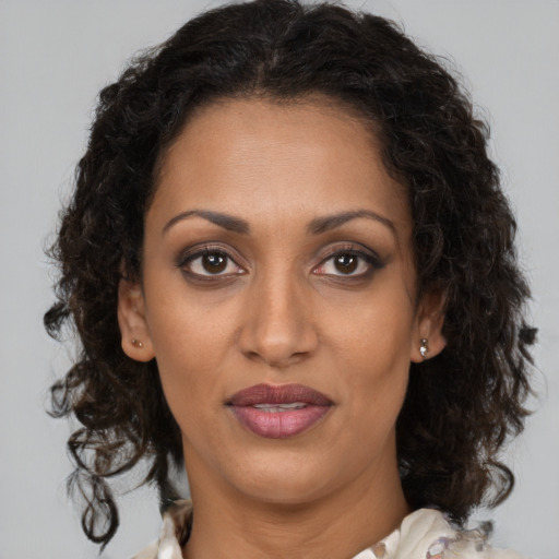 Joyful black adult female with medium  brown hair and brown eyes