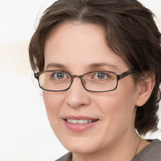 Joyful white adult female with medium  brown hair and blue eyes