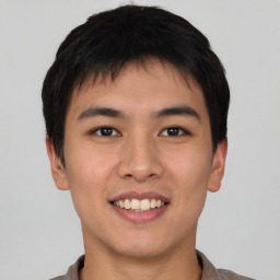 Joyful asian young-adult male with short  brown hair and brown eyes