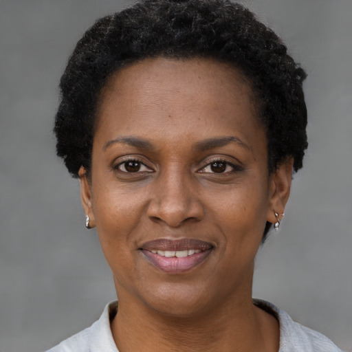 Joyful black adult female with short  black hair and brown eyes