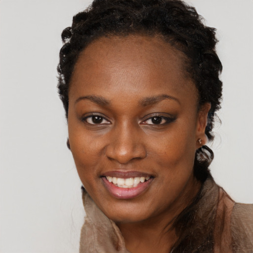 Joyful black young-adult female with long  brown hair and brown eyes