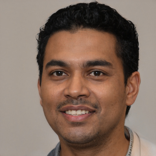 Joyful latino young-adult male with short  black hair and brown eyes