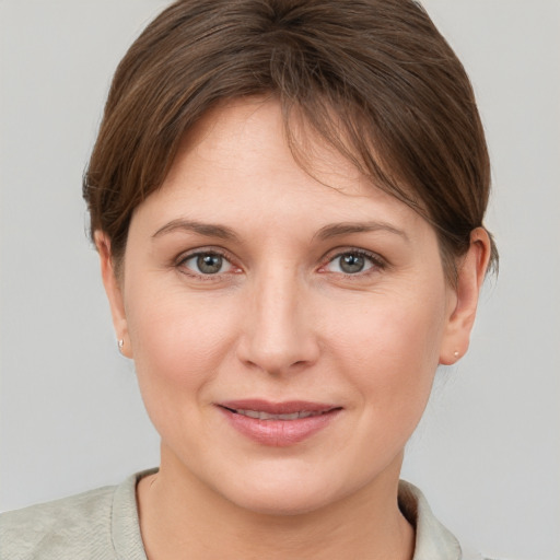 Joyful white young-adult female with short  brown hair and grey eyes