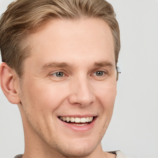 Joyful white adult male with short  brown hair and grey eyes