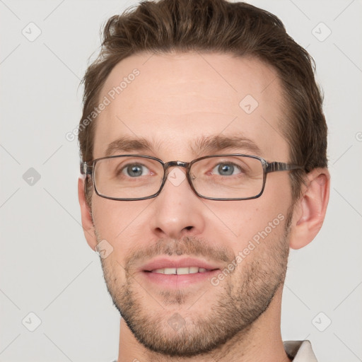 Joyful white young-adult male with short  brown hair and grey eyes