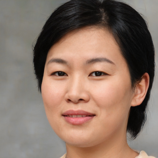 Joyful asian young-adult female with medium  black hair and brown eyes