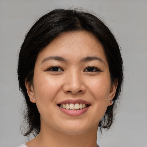 Joyful asian young-adult female with medium  brown hair and brown eyes