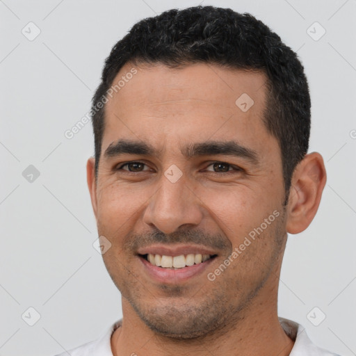 Joyful latino young-adult male with short  black hair and brown eyes