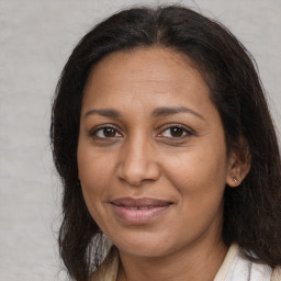 Joyful latino adult female with medium  brown hair and brown eyes