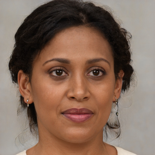 Joyful black adult female with medium  brown hair and brown eyes