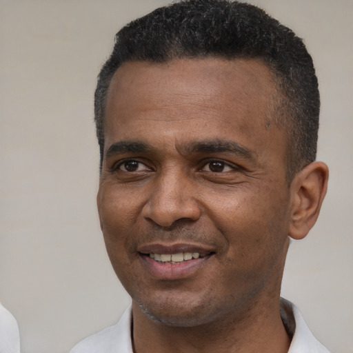 Joyful black young-adult male with short  black hair and brown eyes