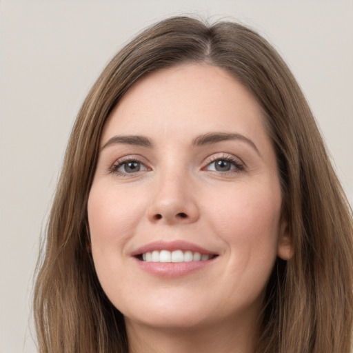 Joyful white young-adult female with long  brown hair and grey eyes