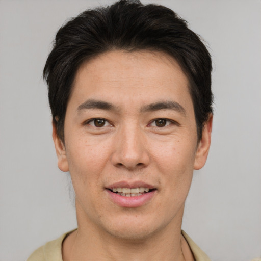 Joyful asian adult male with short  brown hair and brown eyes