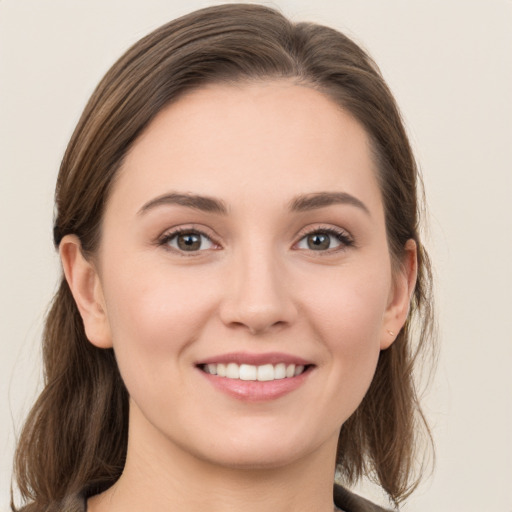 Joyful white young-adult female with medium  brown hair and grey eyes