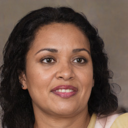 Joyful latino adult female with medium  brown hair and brown eyes