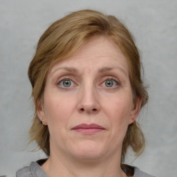 Joyful white adult female with medium  brown hair and blue eyes