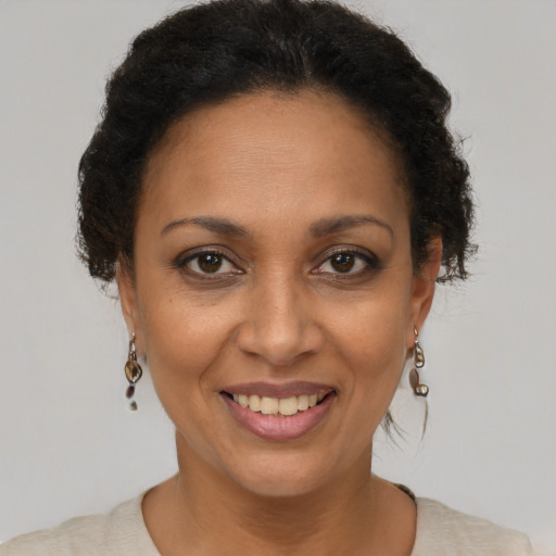 Joyful black adult female with short  brown hair and brown eyes