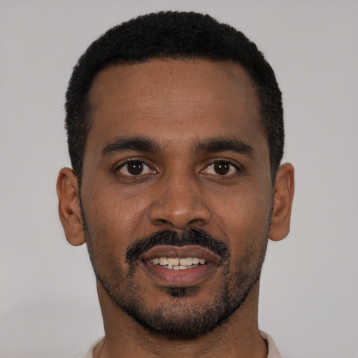 Joyful black young-adult male with short  black hair and brown eyes