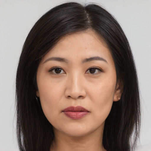 Joyful asian young-adult female with long  brown hair and brown eyes